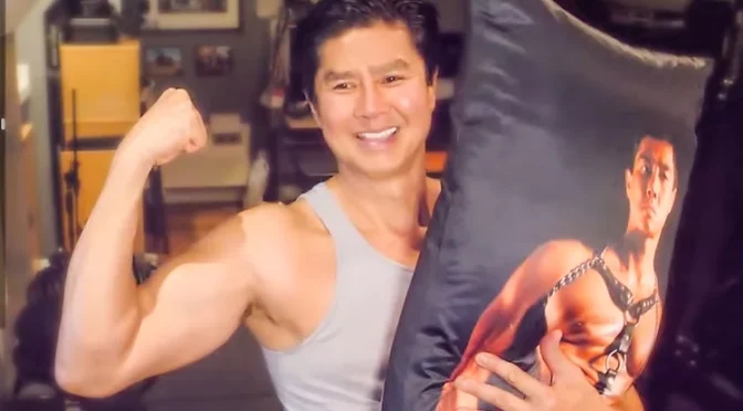 Van Darkholme with his Dakimakura pillow, an item from his mywheats store.